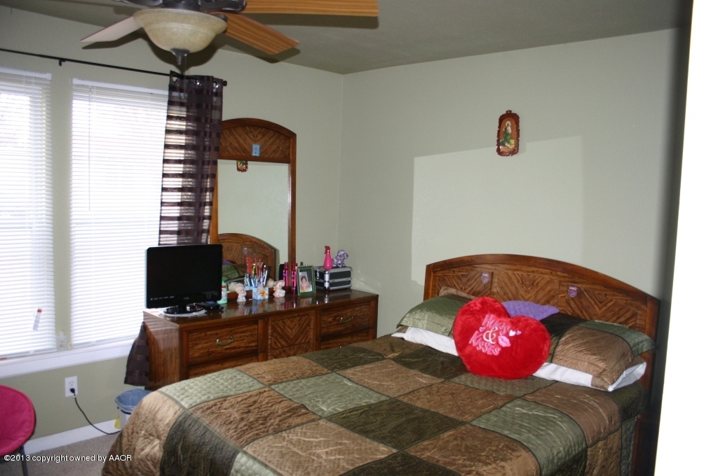 203 Southwest 41st Avenue Amarillo, TX 79110 - Photo 14 of 25 a bedroom with a bed and a potted plant