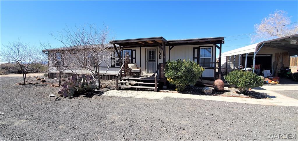 407 South Houck Road Golden Valley, AZ 86413 - Photo 5 of 65 front view of a house with potted plants and a bench