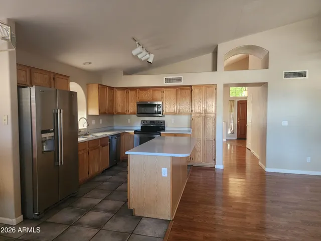 a kitchen with stainless steel appliances granite countertop a refrigerator a stove top oven a sink and dishwasher