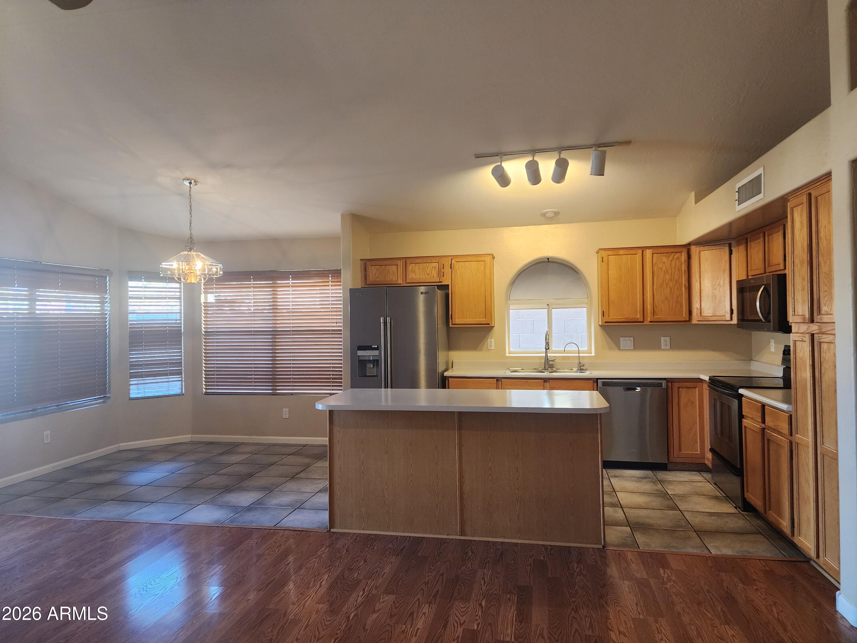 4790 West Tulsa Street Chandler, AZ 85226 - Photo 19 of 30 a kitchen with stainless steel appliances granite countertop a stove a sink dishwasher a refrigerator and a fireplace with wooden floor