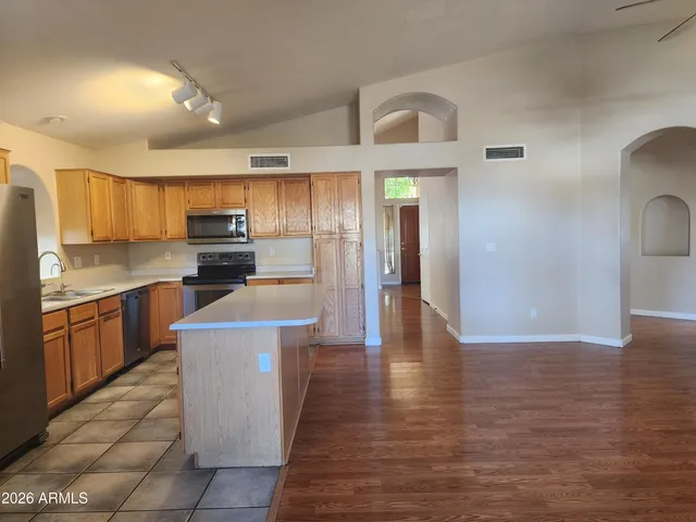 a kitchen with kitchen island wooden cabinets and stainless steel appliances