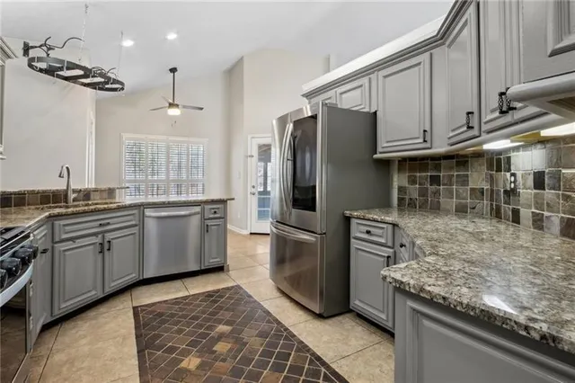 a kitchen with stainless steel appliances granite countertop a refrigerator sink and stove