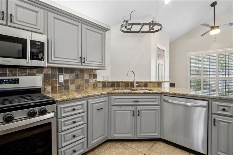 6604 Windbrook Way Flowery Branch, GA 30542 - Photo 22 of 64 a kitchen with stainless steel appliances granite countertop a stove and a sink