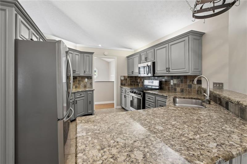 6604 Windbrook Way Flowery Branch, GA 30542 - Photo 25 of 64 a kitchen with stainless steel appliances granite countertop a refrigerator sink and stove
