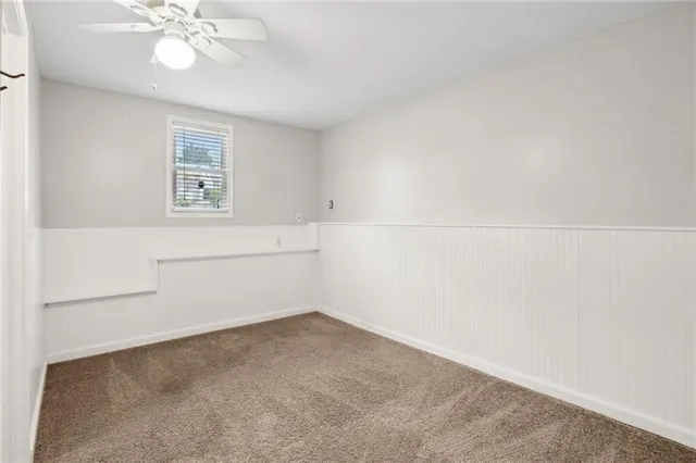 a view of an empty room and a ceiling fan