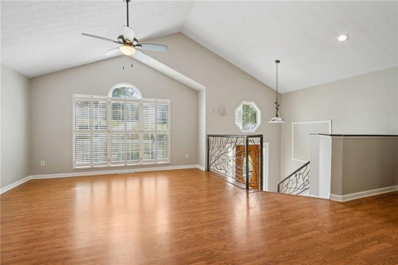 6604 Windbrook Way Flowery Branch, GA 30542 - Photo 10 of 64 a view of an empty room with wooden floor and a window