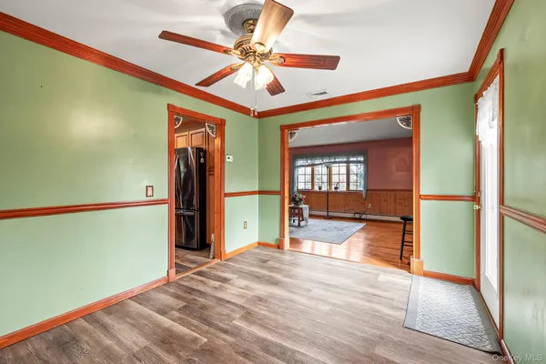 a view of a livingroom with wooden floor and a ceiling fan
