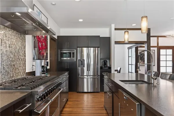 a kitchen with stainless steel appliances granite countertop a sink stove and refrigerator