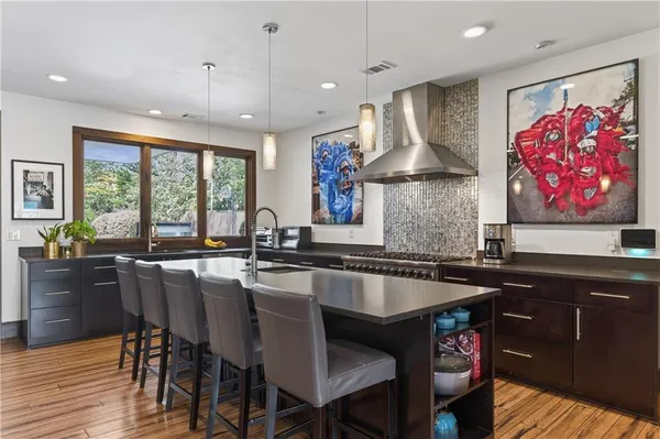 a kitchen with granite countertop a table chairs sink and wooden floor