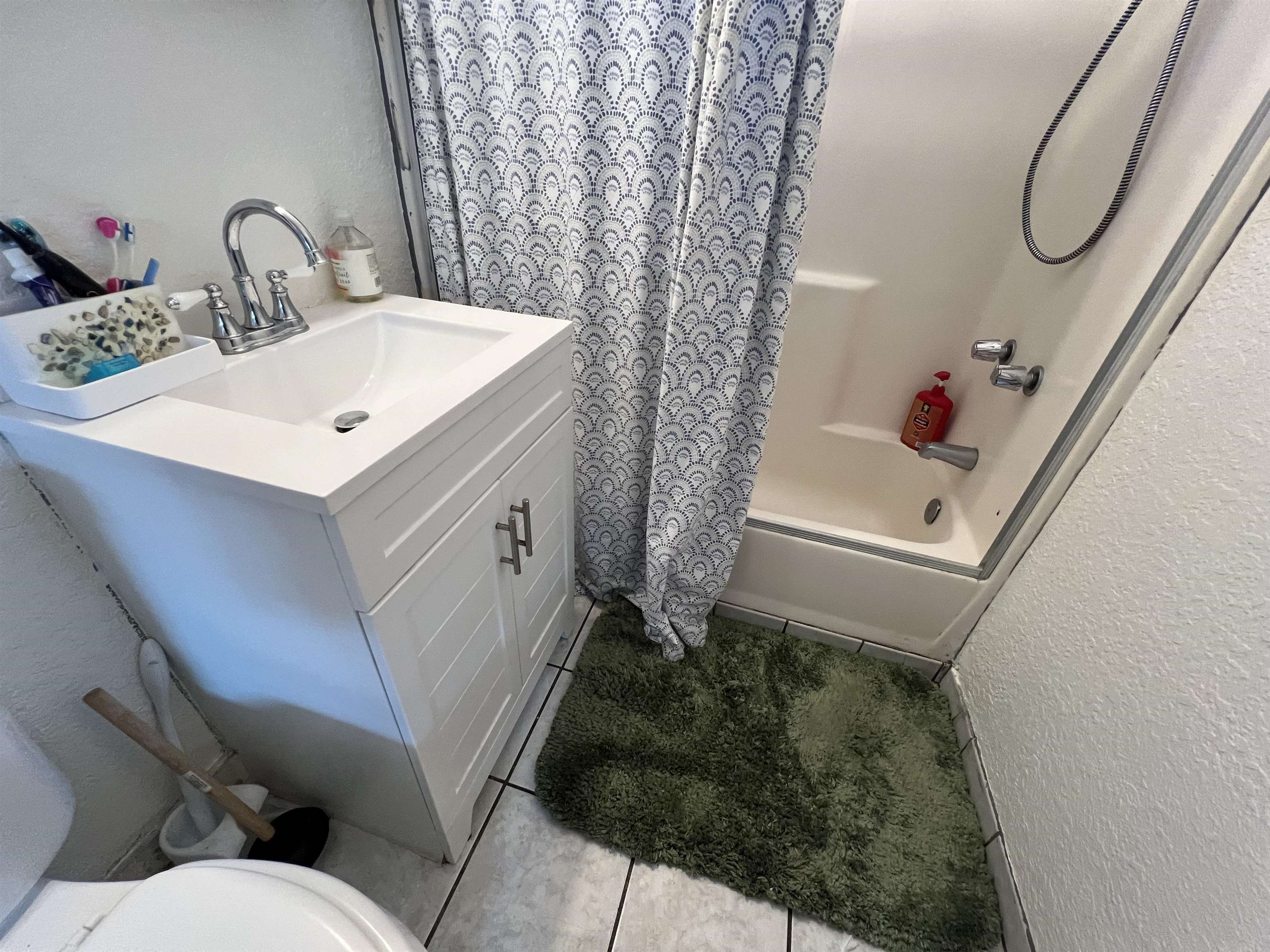 1803 Rosedale Avenue Oakland, CA 94601 - Photo 16 of 28 Bathroom with a textured wall, shower / tub combo with curtain, vanity, and light tile patterned floors