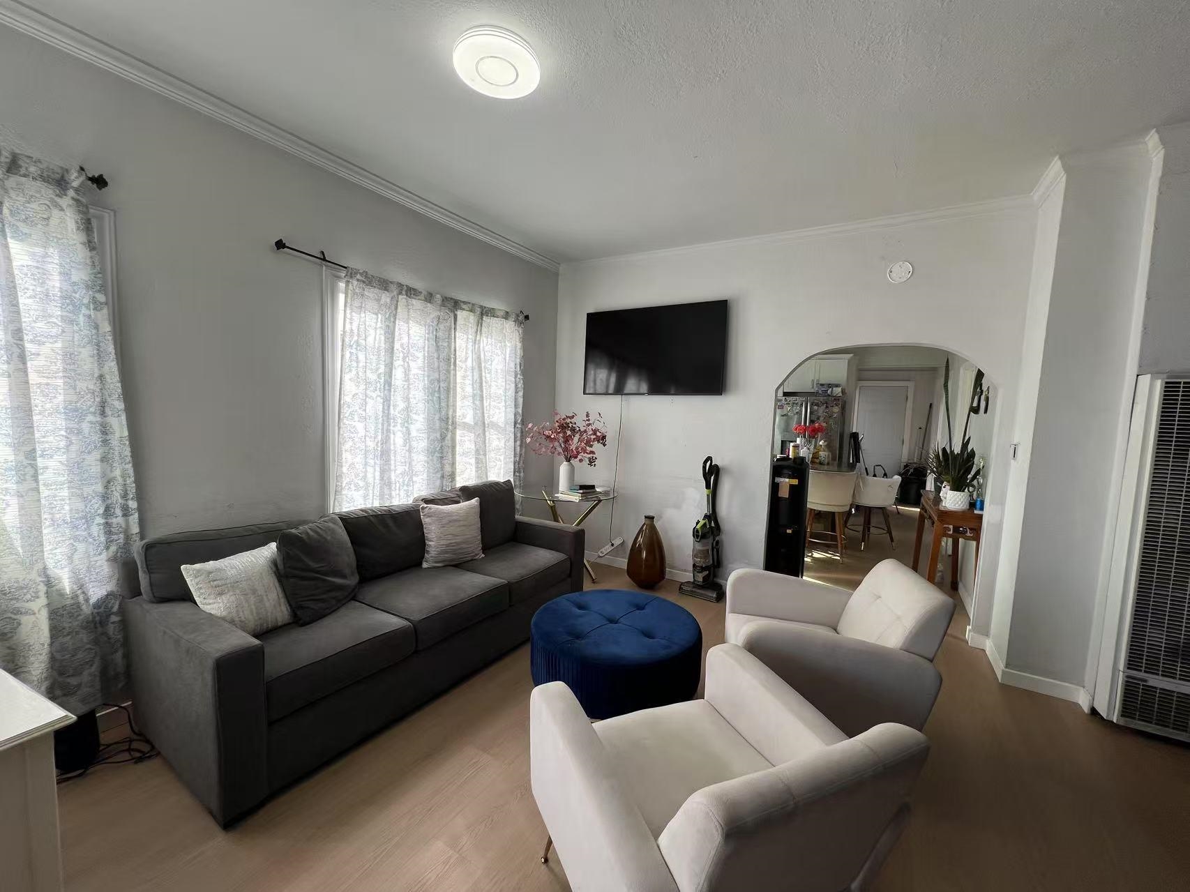 1803 Rosedale Avenue Oakland, CA 94601 - Photo 10 of 28 Living room featuring arched walkways, wood finished floors, a heating unit, and crown molding