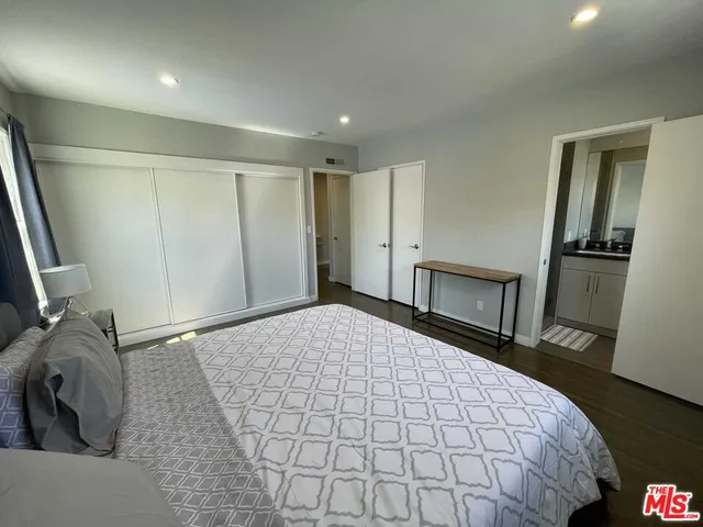 a spacious bedroom with a bed and wooden floor