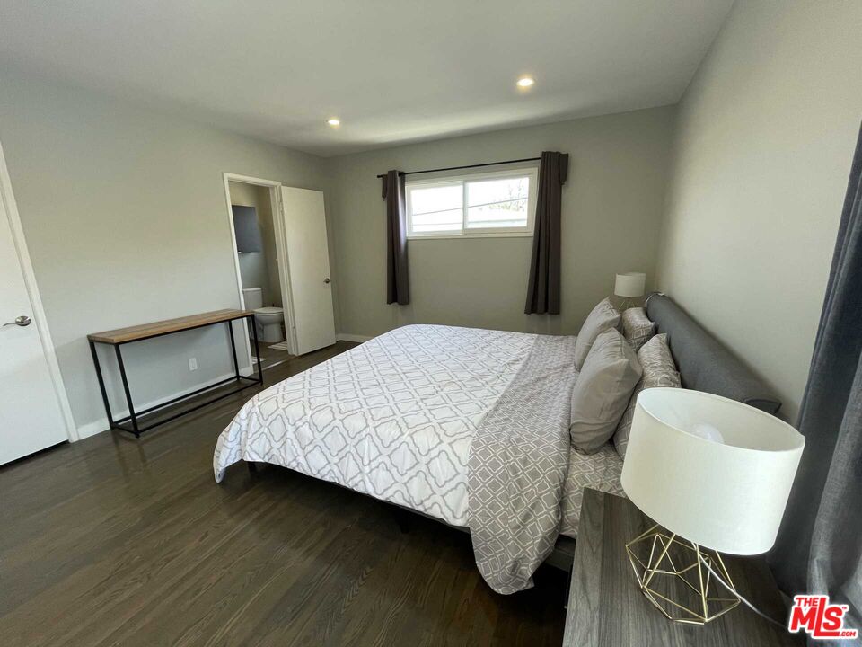 348 South Elm Drive, Unit 6 Beverly Hills, CA 90212 - Photo 14 of 17 a bedroom with a bed a mirror and wooden floor