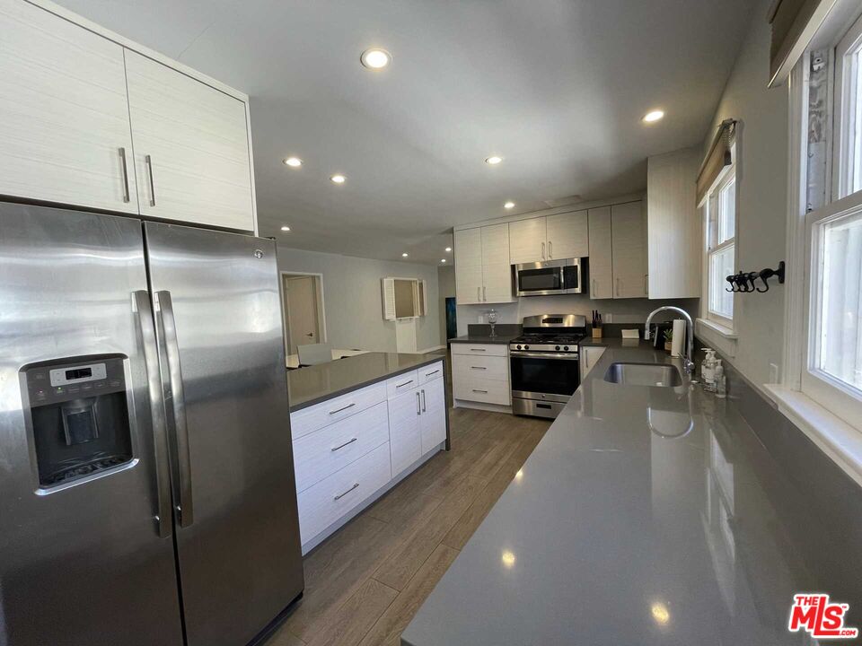 348 South Elm Drive, Unit 6 Beverly Hills, CA 90212 - Photo 6 of 17 a kitchen with stainless steel appliances granite countertop a refrigerator a sink a stove and a refrigerator with wooden floor