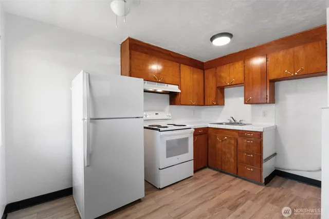 a kitchen with stainless steel appliances granite countertop a refrigerator a sink and a stove