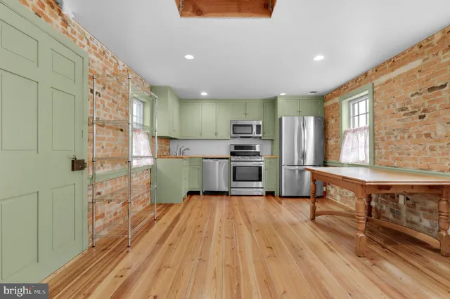 a kitchen with stainless steel appliances kitchen island granite countertop a stove a sink and a refrigerator