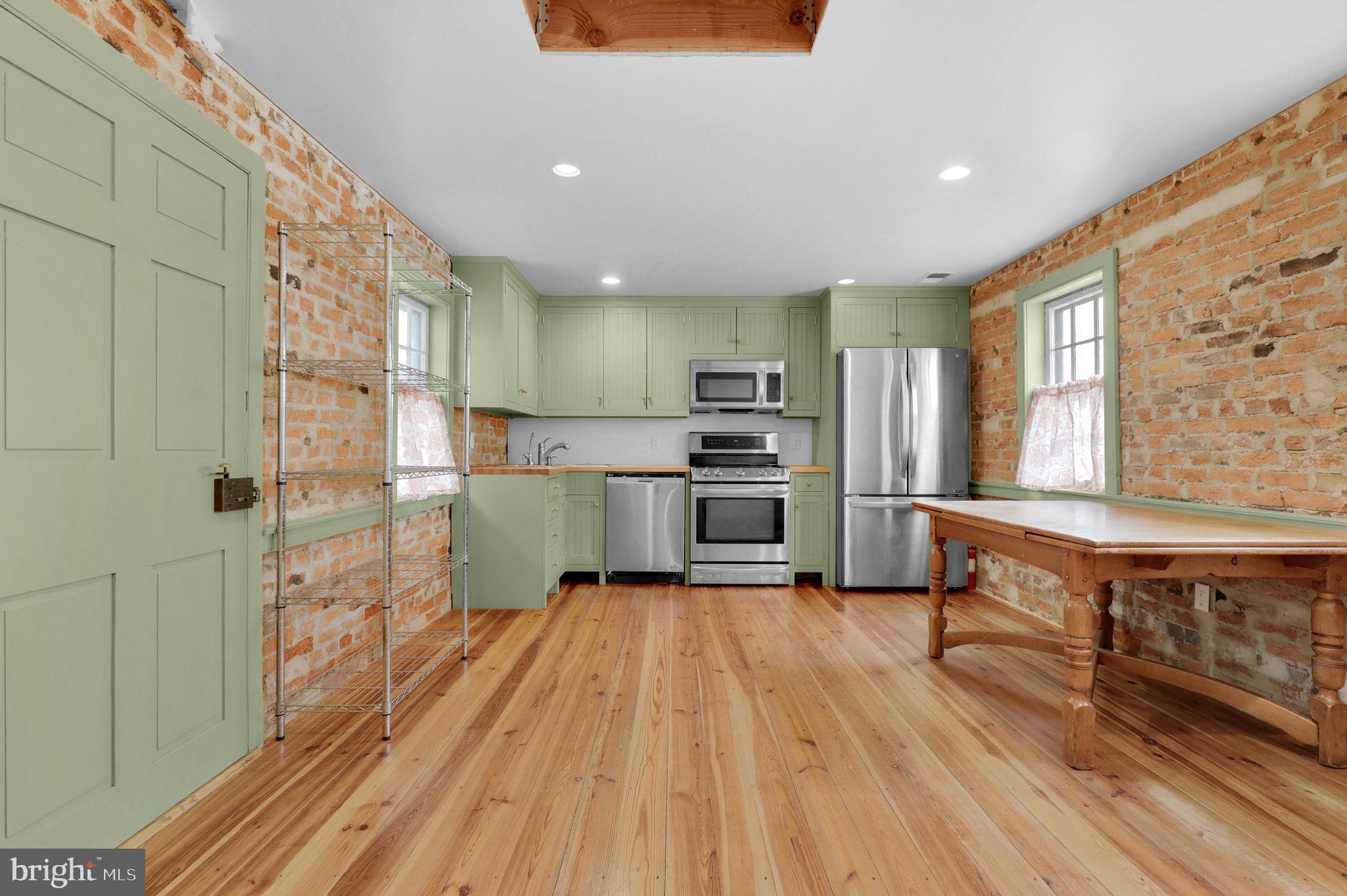28 Potomac Street Boonsboro, MD 21713 - Photo 12 of 52 a kitchen with kitchen island wooden floors appliances and dining table