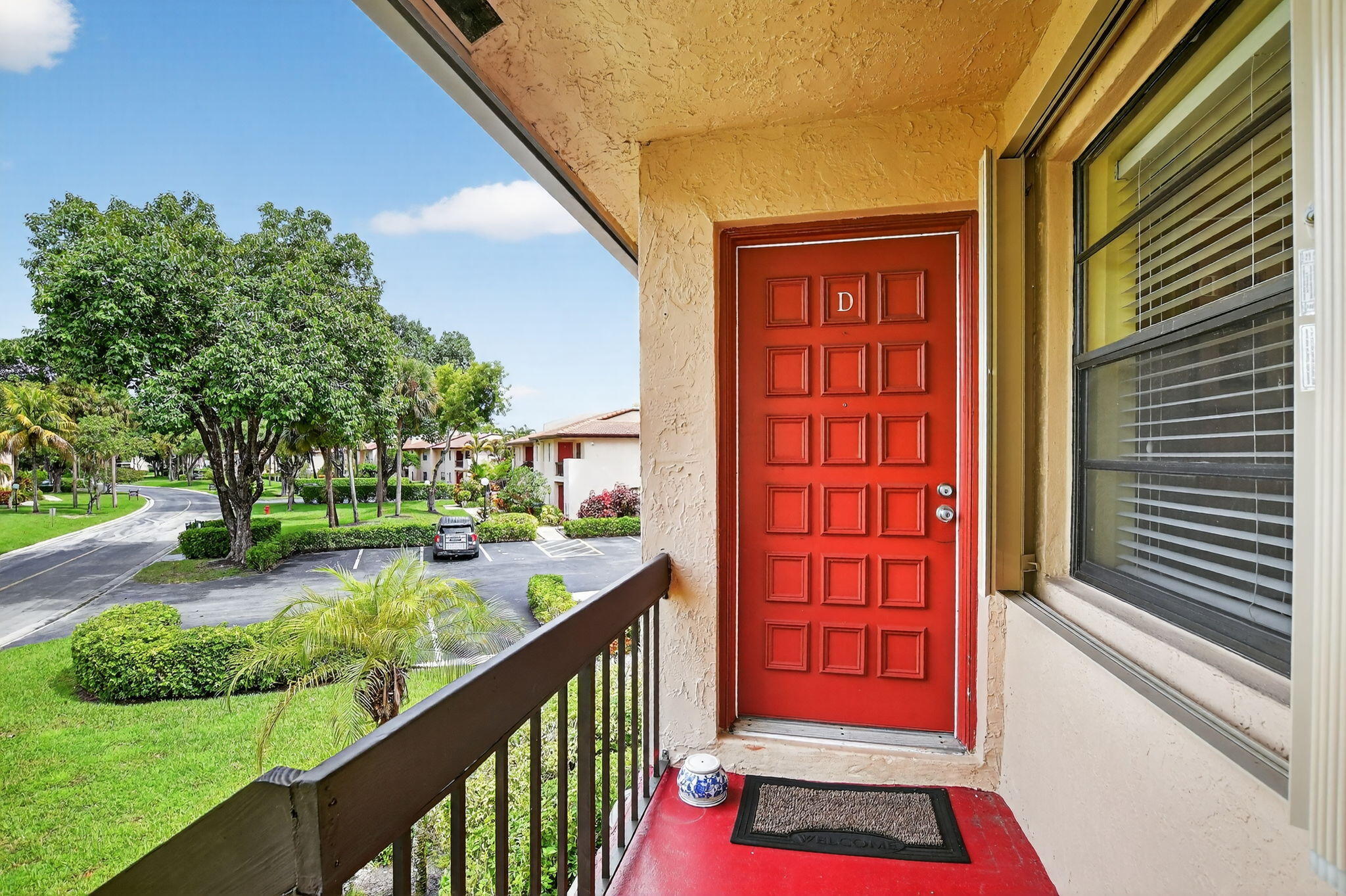 9268 Vista Del Lago, Unit 26D Boca Raton, FL 33428 - Photo 2 of 34 a view of a balcony with red door and deck