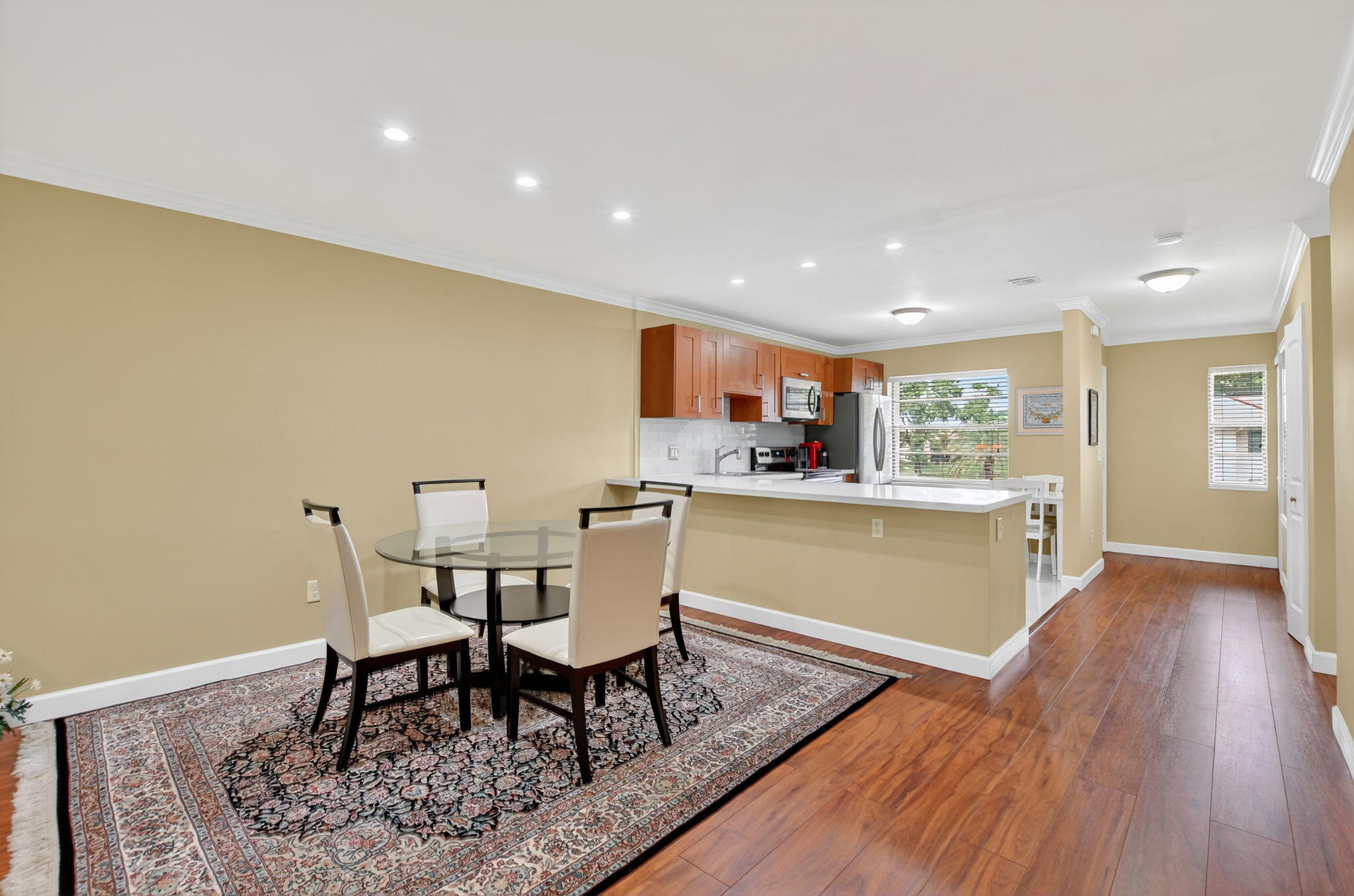 9268 Vista Del Lago, Unit 26D Boca Raton, FL 33428 - Photo 10 of 34 a kitchen with a dining table chairs and wooden floor
