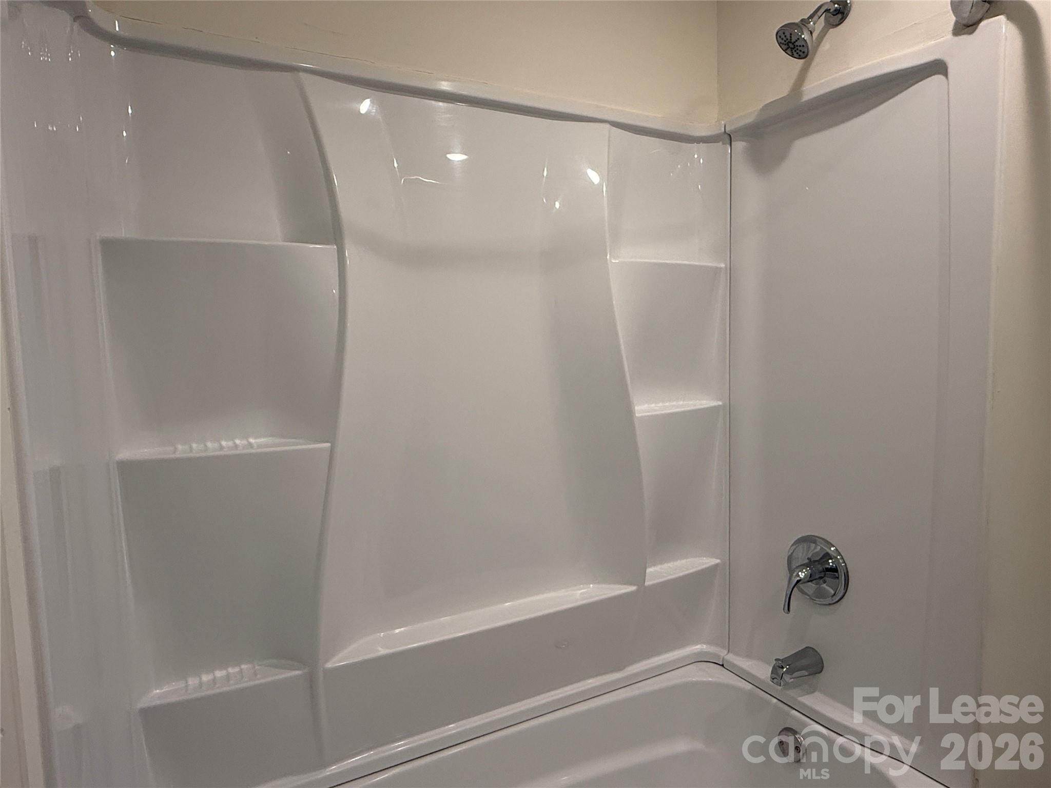 2021 Oakdale Road, Unit K Charlotte, NC 28216 - Photo 11 of 13 a bathroom with a bathtub and a shower