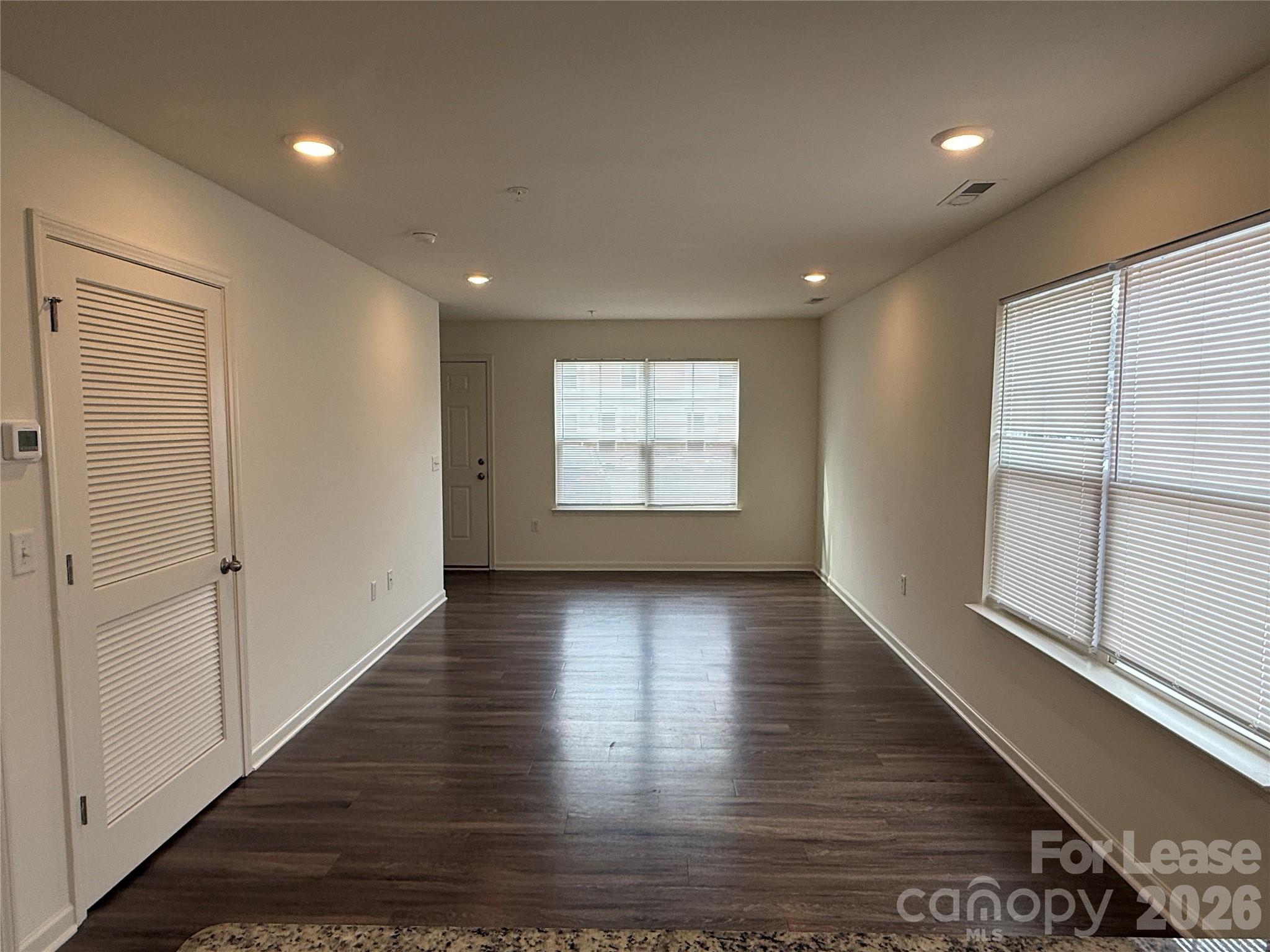 2021 Oakdale Road, Unit K Charlotte, NC 28216 - Photo 2 of 13 an empty room with wooden floor and windows