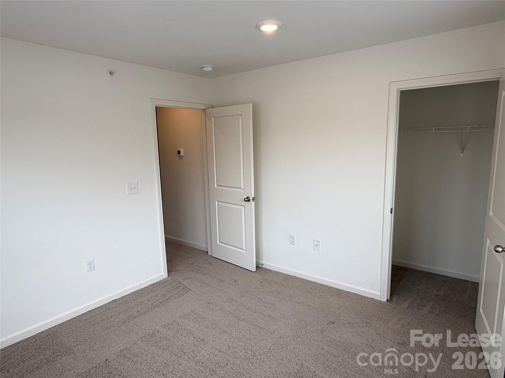 2021 Oakdale Road, Unit K Charlotte, NC 28216 - Photo 9 of 13 an empty room with closet area