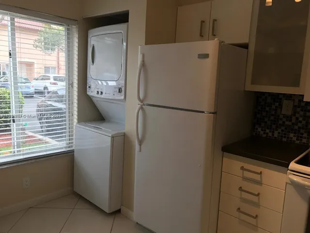 a white refrigerator freezer and a stove sitting inside of a kitchen