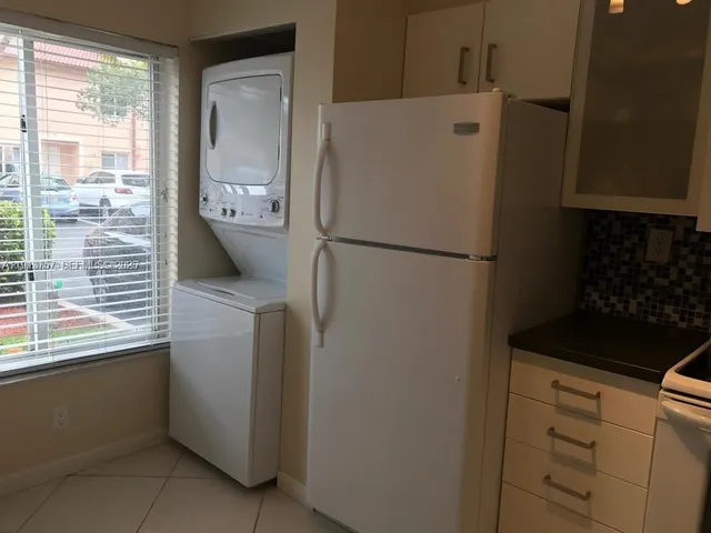 a white refrigerator freezer and a stove sitting inside of a kitchen