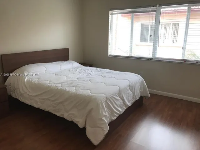 a bed sitting in a bedroom next to a window