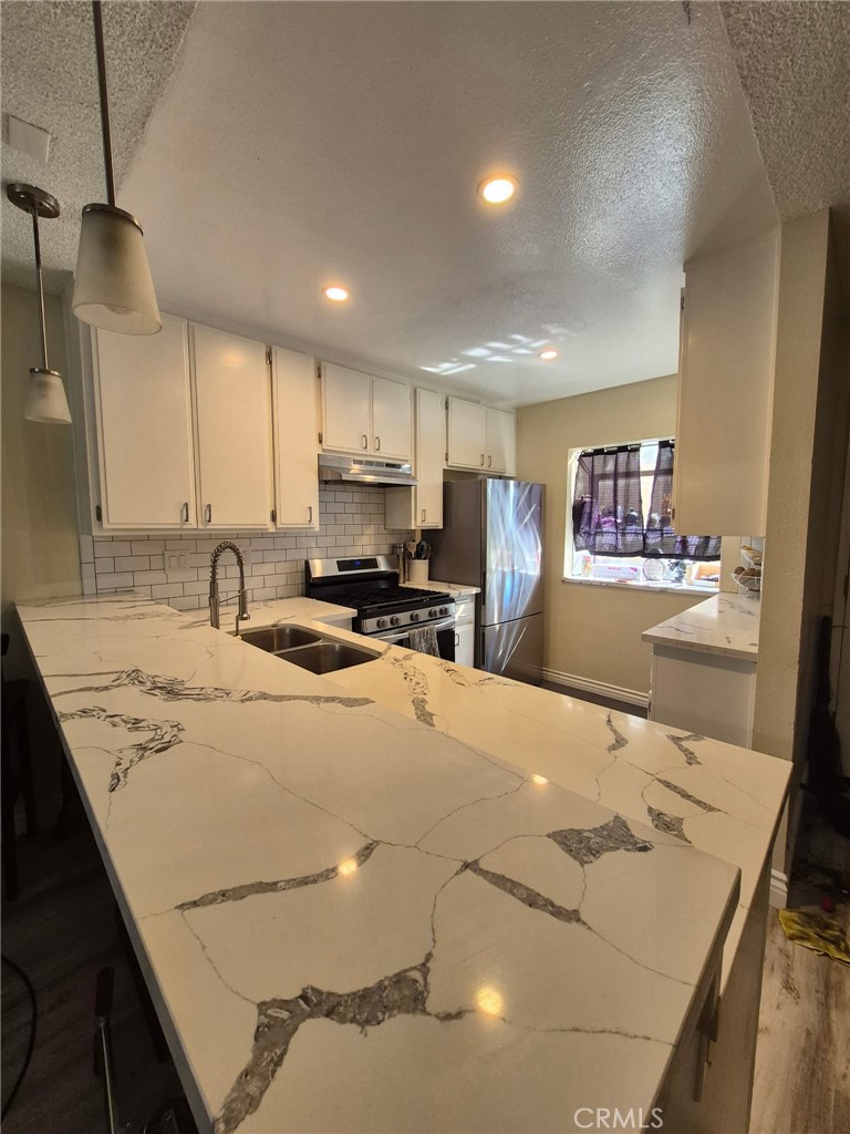 4140 Workman Mill Road, Unit 115 Whittier, CA 90601 - Photo 7 of 14 a kitchen with stainless steel appliances granite countertop a sink refrigerator and cabinets