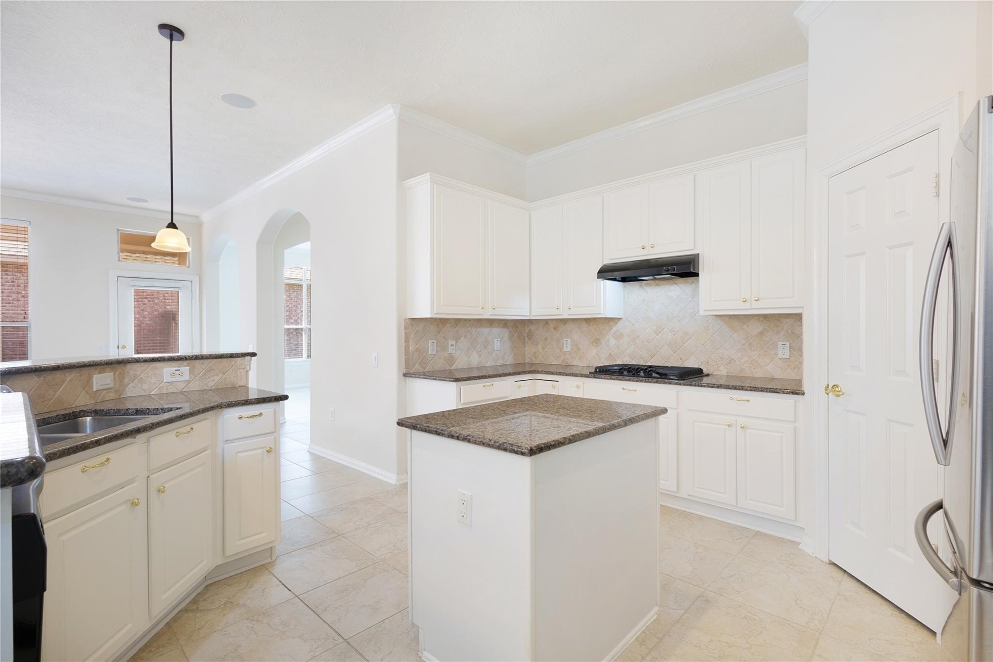 43 Tarrytown Way Conroe, TX 77384 - Photo 19 of 40 a kitchen with stainless steel appliances granite countertop a sink a stove a refrigerator and white cabinets