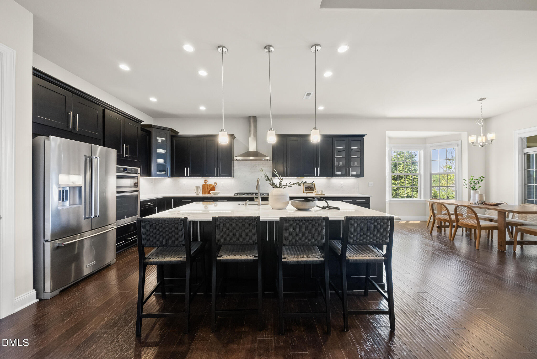 2648 Beckwith Road Apex, NC 27523 - Photo 11 of 59 a kitchen with stainless steel appliances kitchen island granite countertop a dining table chairs refrigerator and sink