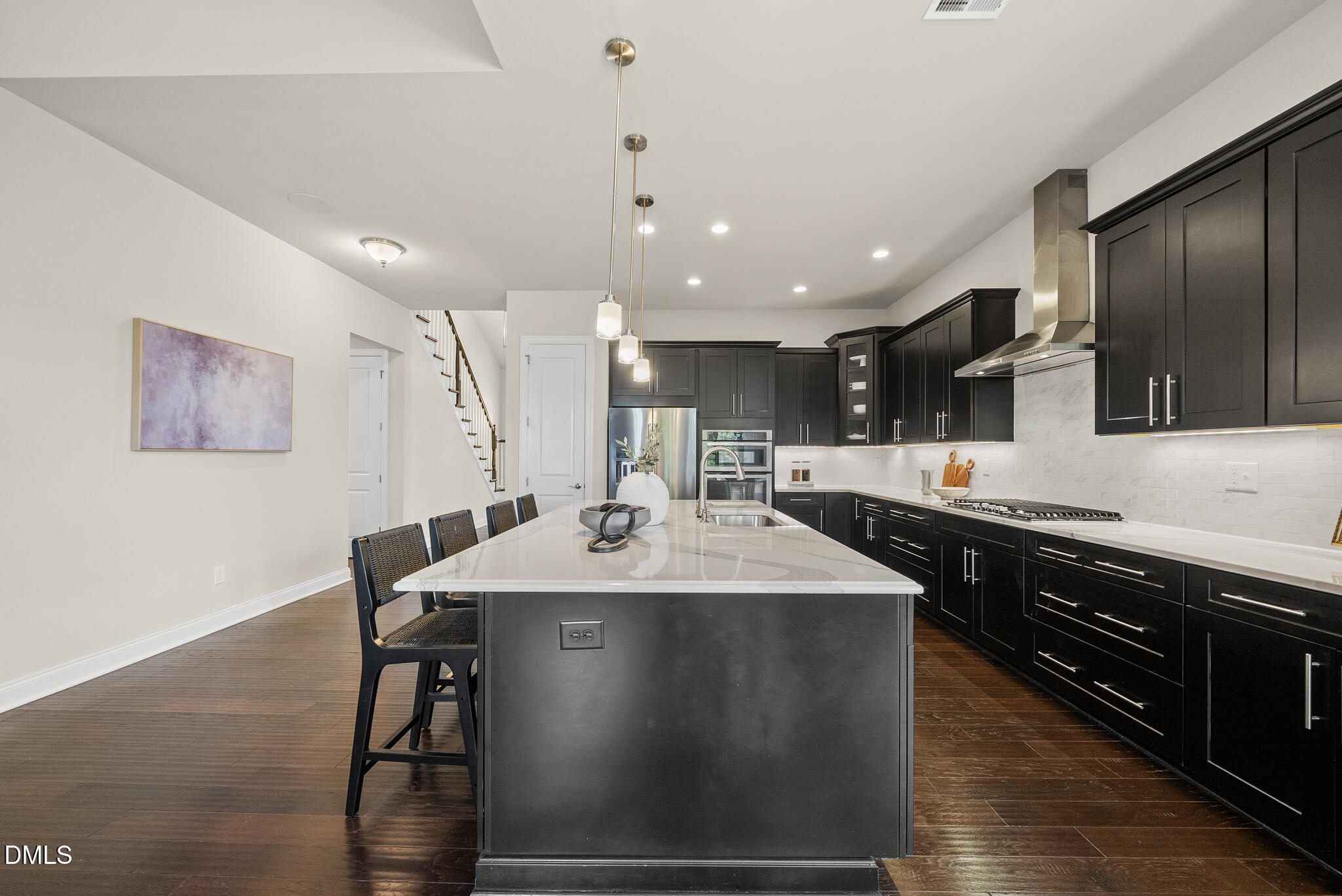 2648 Beckwith Road Apex, NC 27523 - Photo 14 of 59 a kitchen with stainless steel appliances granite countertop a sink a stove a refrigerator and black cabinets with wooden floor