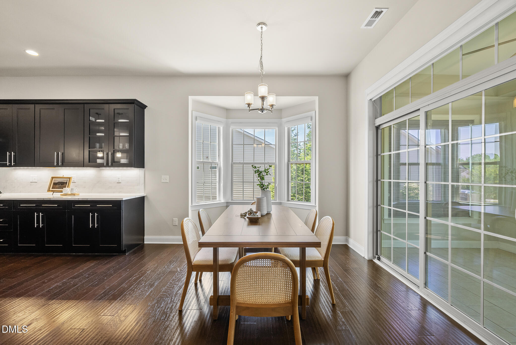2648 Beckwith Road Apex, NC 27523 - Photo 22 of 59 a dining room with wooden floor a chandelier a wooden table and chairs