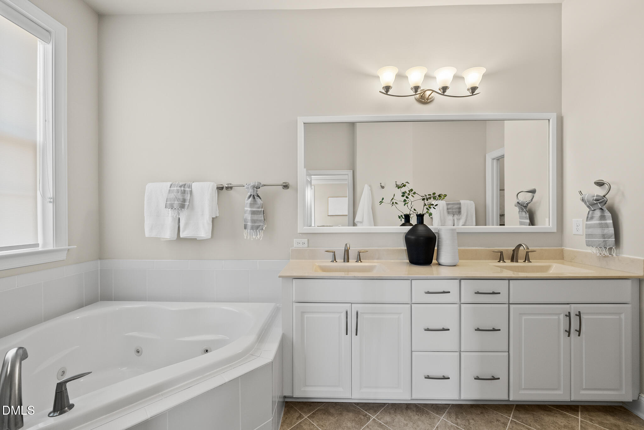 2648 Beckwith Road Apex, NC 27523 - Photo 28 of 59 a bathroom with a double vanity sink a large mirror a bathtub and window