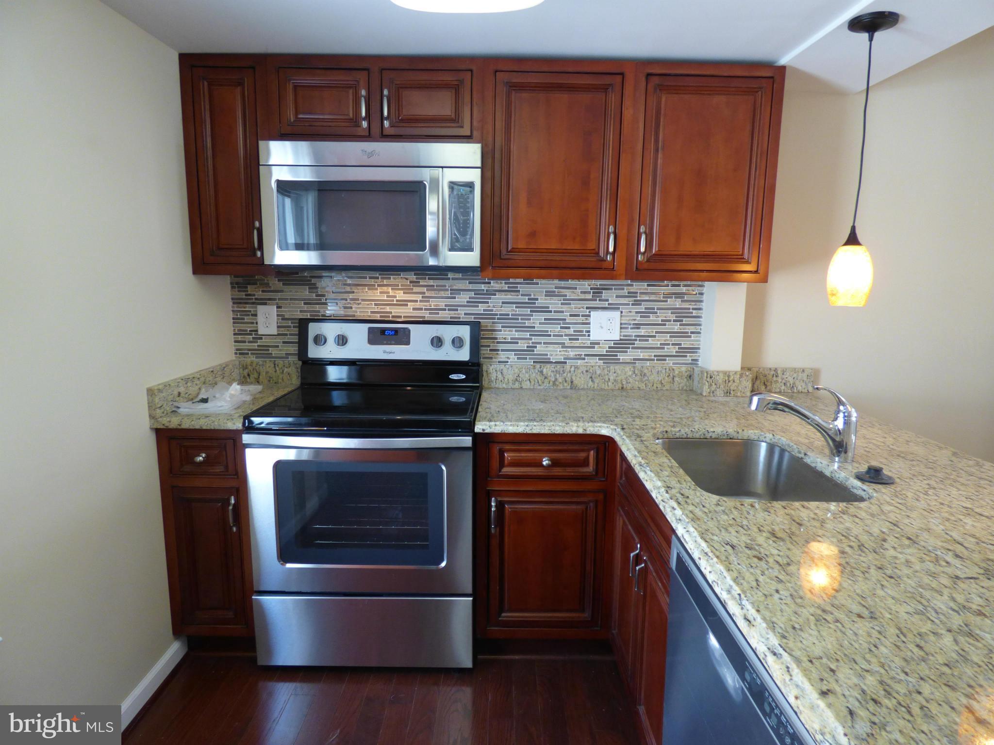 2064 Bethel Road Finksburg, MD 21048 - Photo 12 of 30 a kitchen with granite countertop wood cabinets and stainless steel appliances