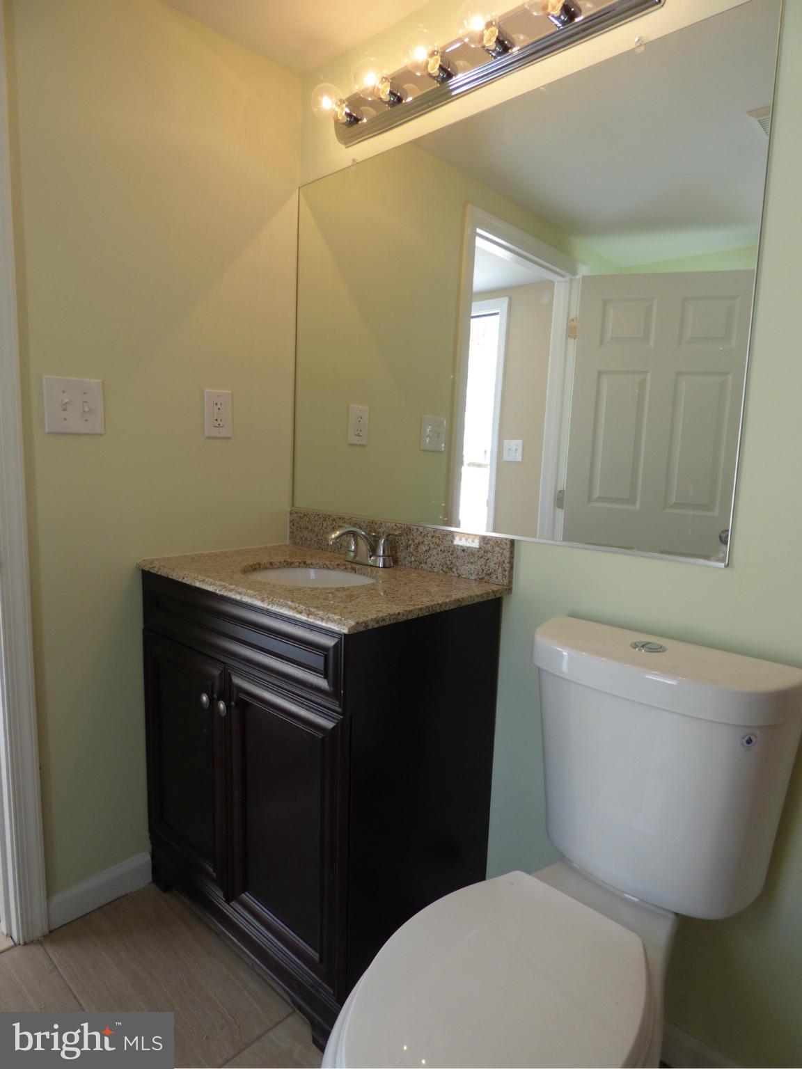 2064 Bethel Road Finksburg, MD 21048 - Photo 24 of 30 a bathroom with a granite countertop toilet sink and mirror