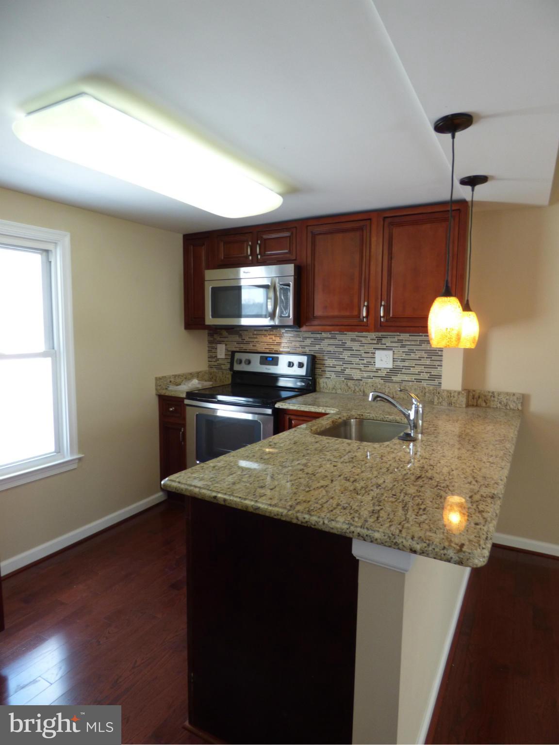 2064 Bethel Road Finksburg, MD 21048 - Photo 7 of 30 a kitchen with a sink a microwave a stove and cabinets