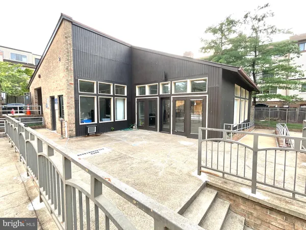 a view of a house with a balcony and floor to ceiling windows