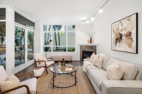 a living room with furniture kitchen view and a large window