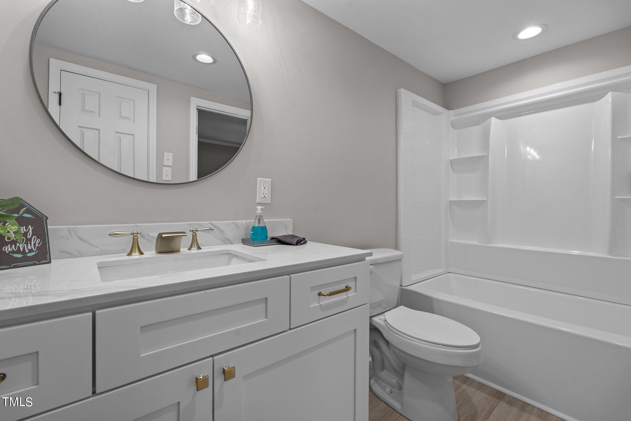3520 Maxwell Road Autryville, NC 28318 - Photo 29 of 38 a bathroom with a toilet a sink a mirror and vanity