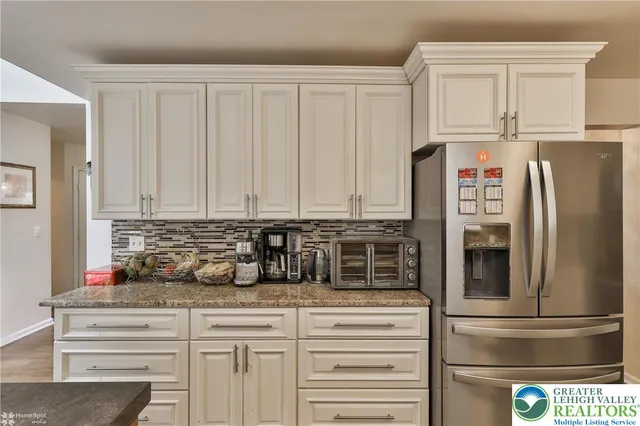 a kitchen with stainless steel appliances granite countertop a refrigerator and a sink