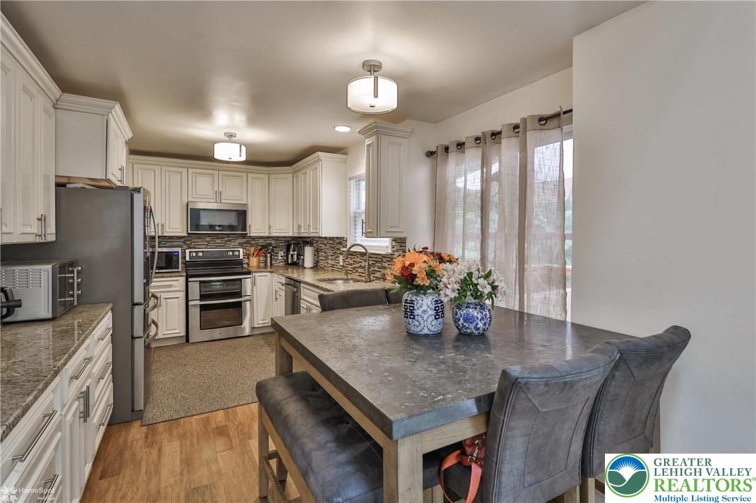 204 Ridings Circle Macungie, PA 18062 - Photo 20 of 53 a kitchen with stainless steel appliances granite countertop a stove refrigerator a sink dishwasher with a dining table and chairs