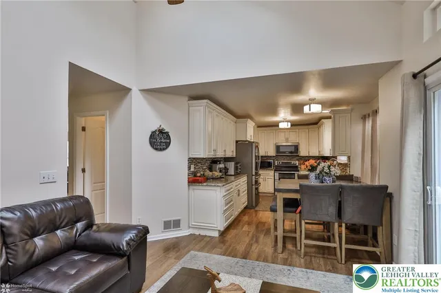 a living room with stainless steel appliances kitchen island granite countertop furniture and a view of kitchen