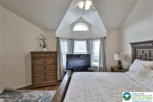 a bedroom with a bed and a flat tv screen on dresser