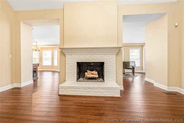 a living room with wooden floor and a fireplace