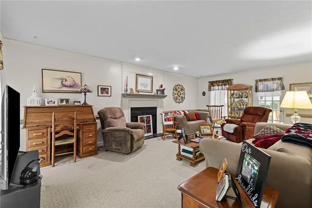 a living room with furniture a fireplace and a window