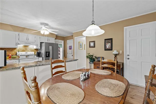 a dining room with furniture a chandelier and wooden floor