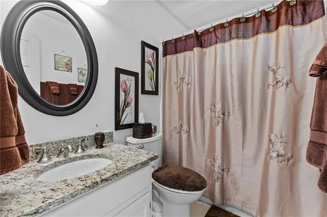 a spacious bedroom with a bed a computer on table and a window