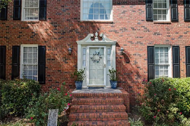 a front view of a building with brick walls and windows